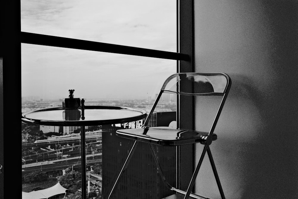 a black and white photo of a chair and a table