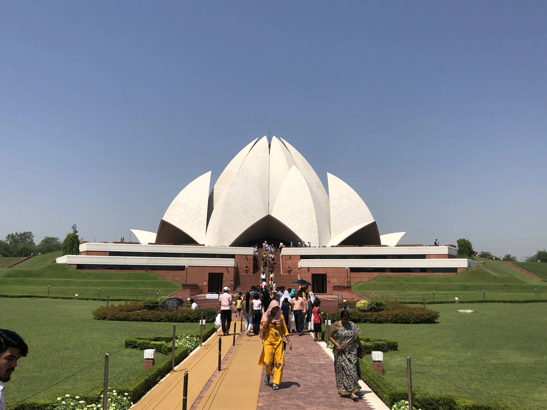 The serene white petals of the Lotus Temple framed against a bright blue sky, inviting peaceful reflection.