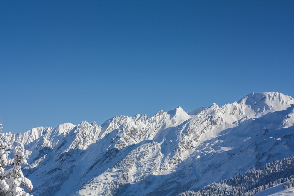 a snow covered mountain with a ski lift in the foreground