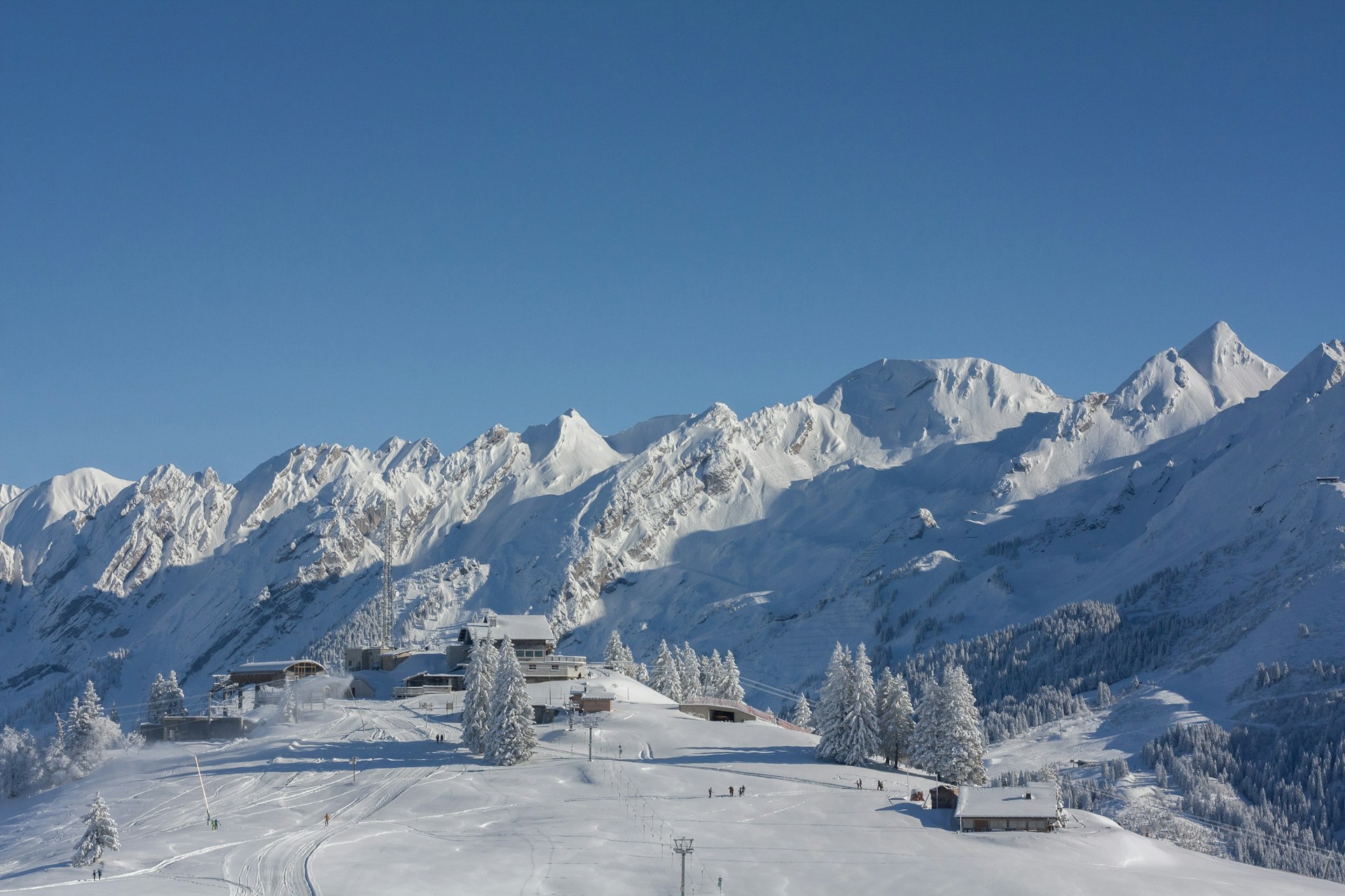 a snow covered mountain with a ski lodge in the foreground