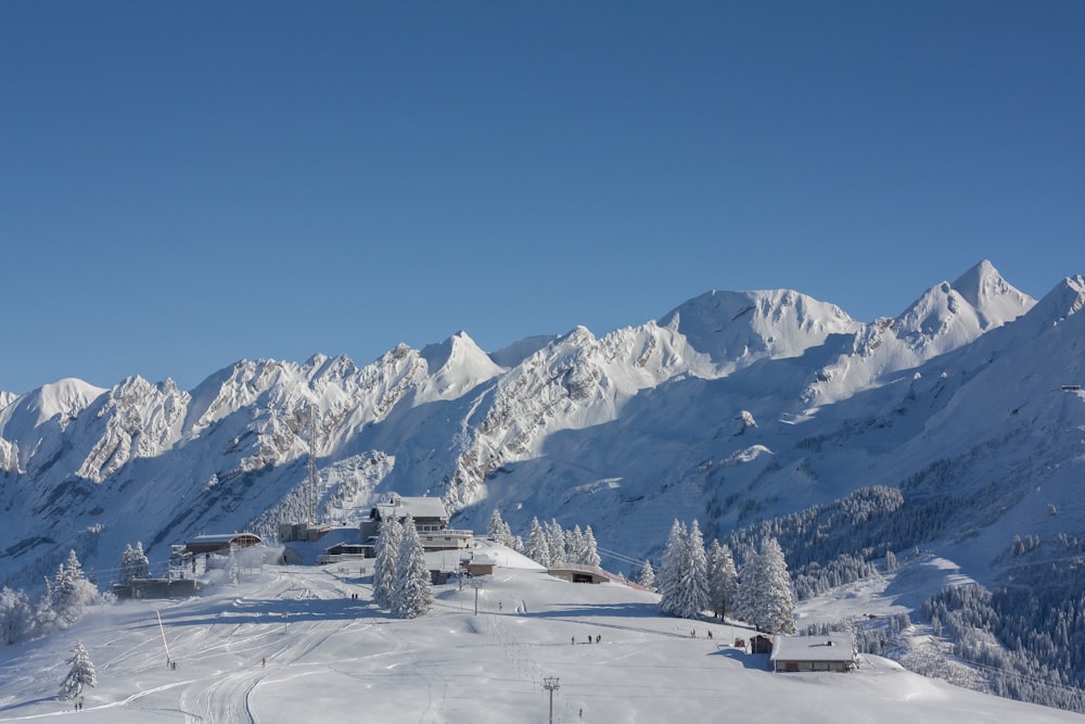 a snow covered mountain with a ski lodge in the foreground