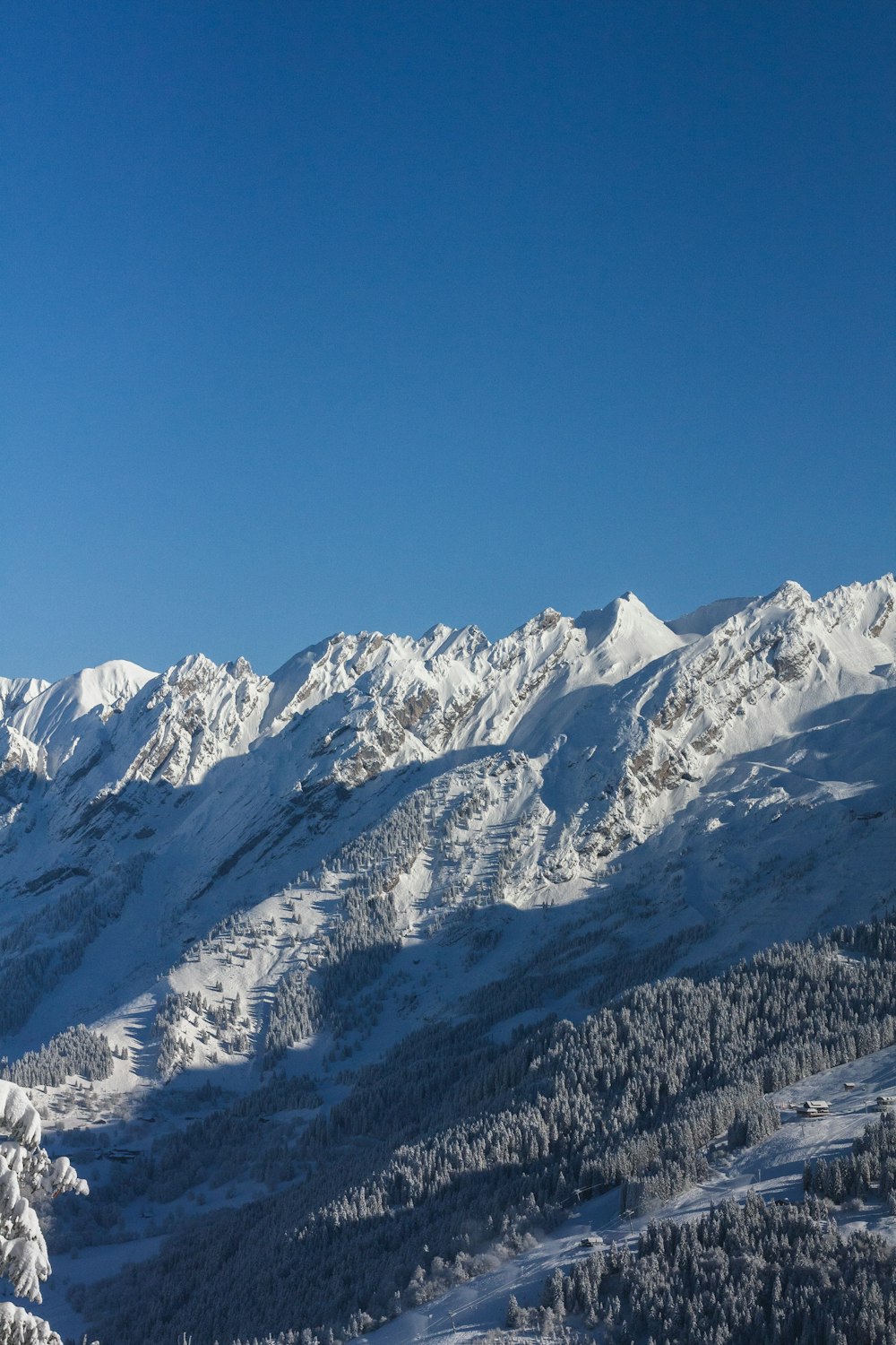 a snow covered mountain with a ski lift in the foreground