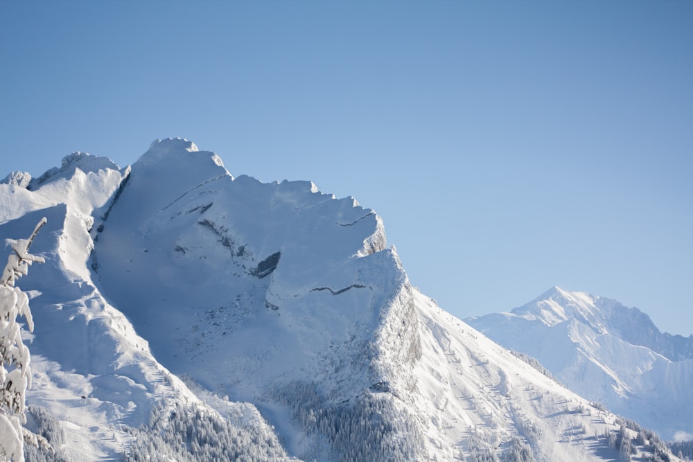 a large mountain covered in snow under a blue sky