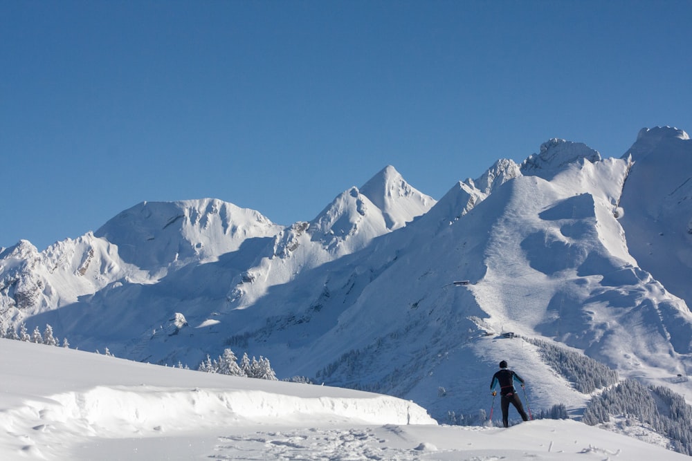 a man standing on top of a snow covered slope