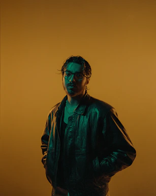 Close-up of a handcrafted tribal leather jacket with bronze accents under soft, moody lighting.