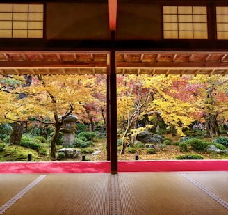 A cozy ryokan nestled among vibrant autumn leaves in Japan, inviting Indonesian travelers to experience authentic hospitality.