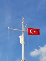 a flag on top of a pole with a sky background