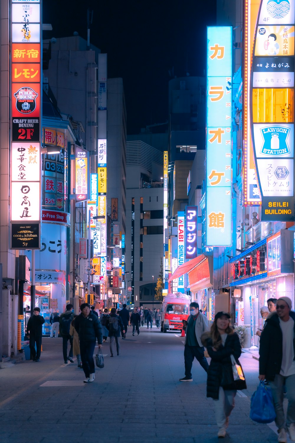 高層ビルの隣の通りを歩いている人々のグループ