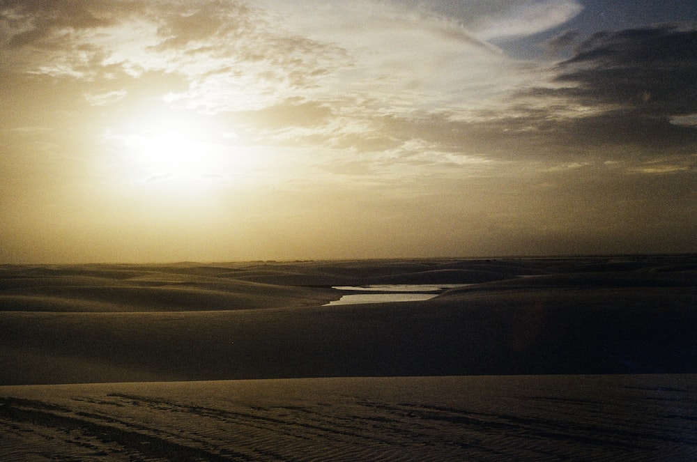 o sol está se pondo sobre as dunas de areia