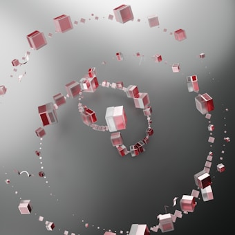 A spiral formation of semi-transparent cubes with red and white colors set against a gradient gray background. The cubes appear to vary in size, creating a flowing, dynamic visual effect.