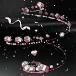 Floating pink and white cubes, heart shapes, and ribbons are spiraling through a dark space filled with small glowing particles. The composition has a dynamic and whimsical feel with a slight cosmic or futuristic ambiance.