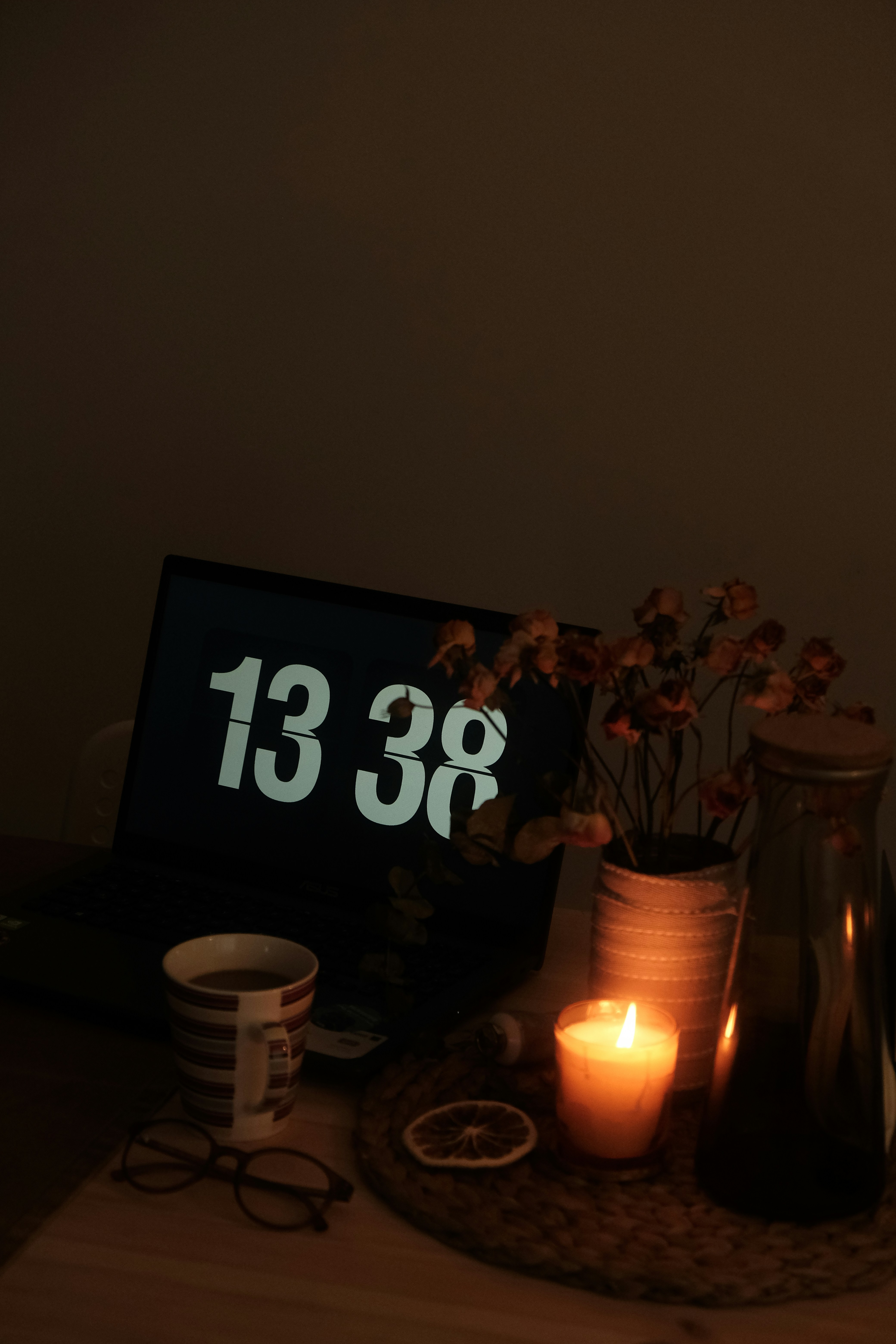 a table topped with a lit candle next to a sign