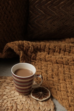 A charcoal gray beanie casually placed beside a muted gold coffee mug.