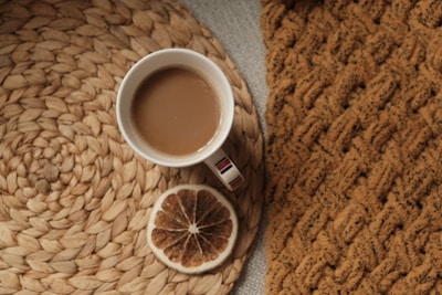 Quiet morning scene with a cup of coffee and crochet placemat on an off-white table.