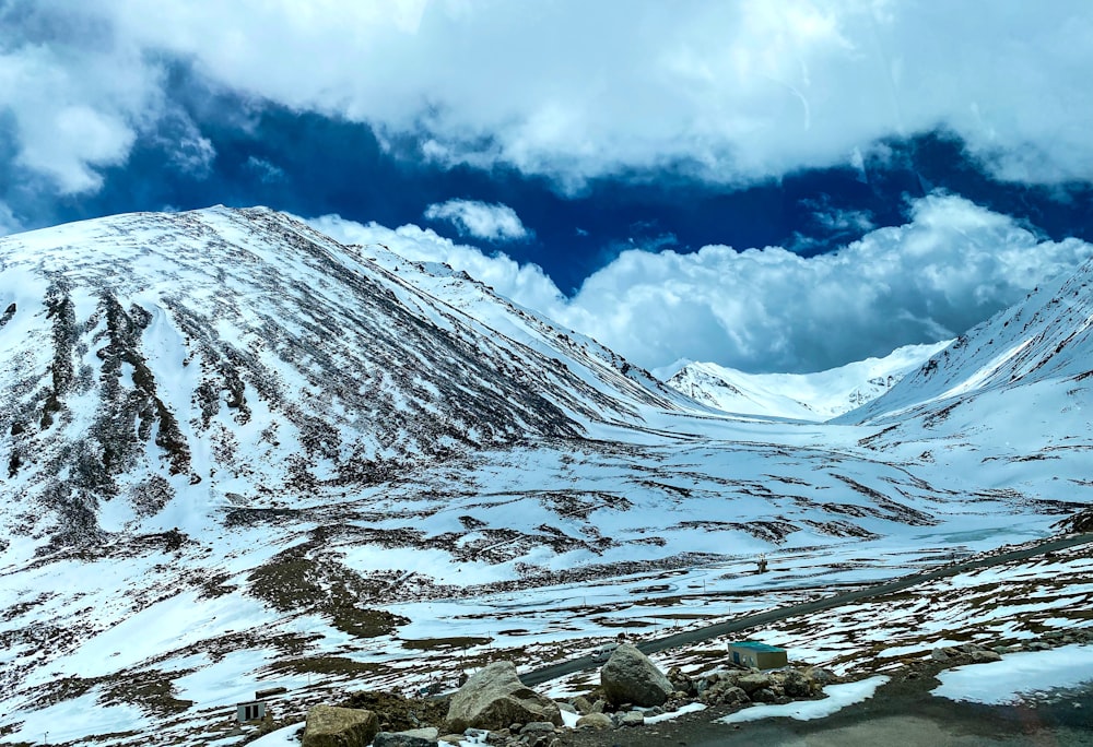 a snow covered mountain with rocks and a body of water