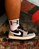 Close-up of trendy sneakers against a graffiti wall.