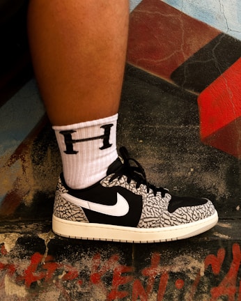 Close-up of trendy sneakers against a graffiti wall.