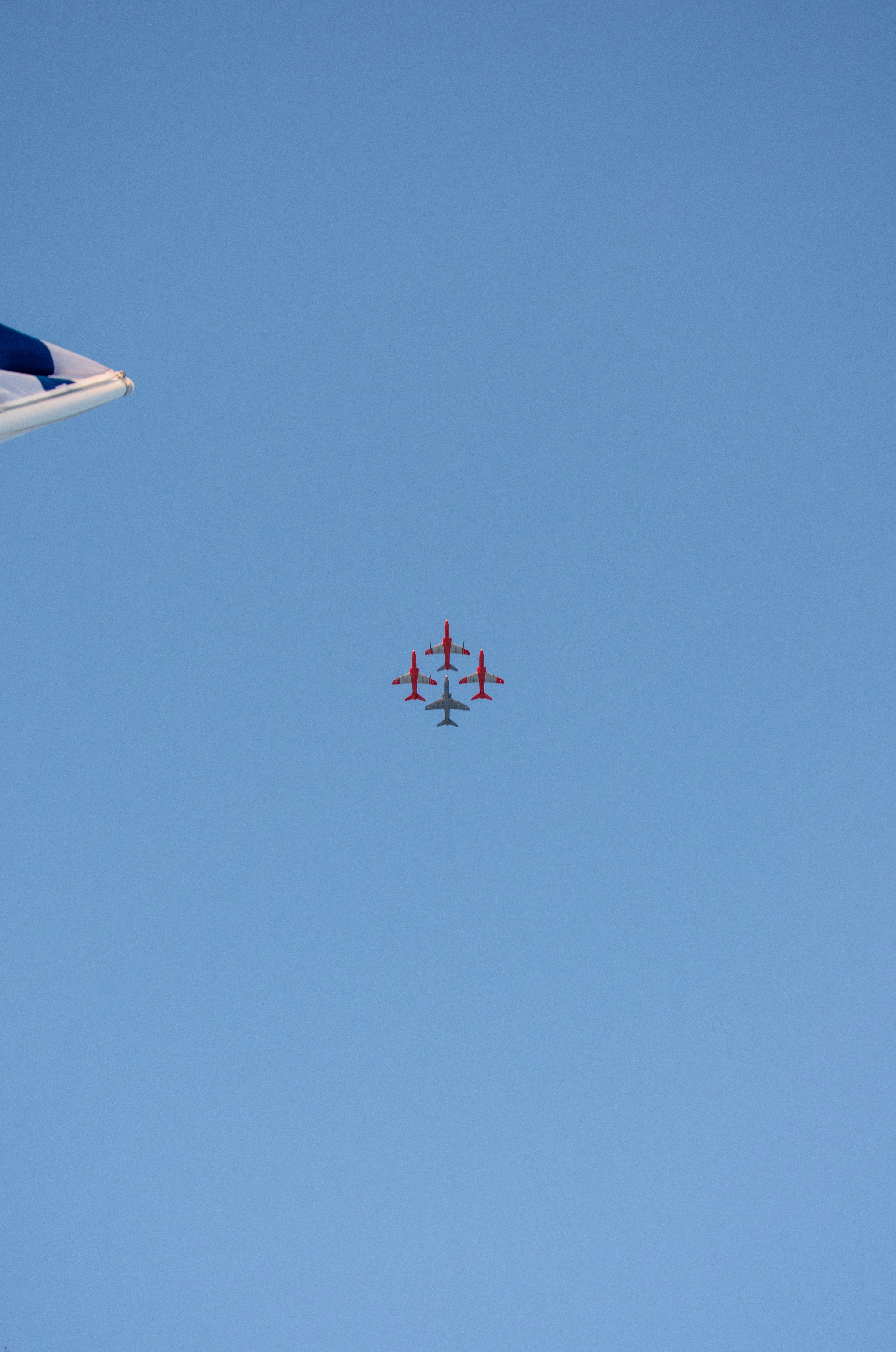 a group of red and white airplanes flying in the sky