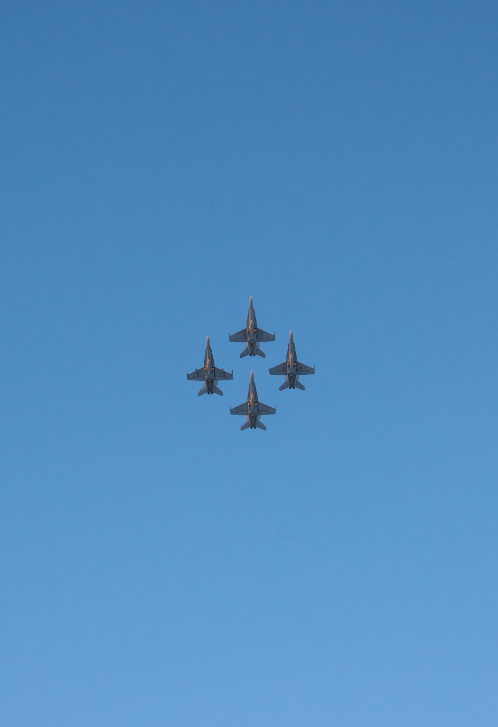 a group of fighter jets flying through a blue sky