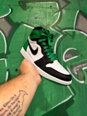 Close-up of vibrant Nike sneakers against a colorful graffiti wall.