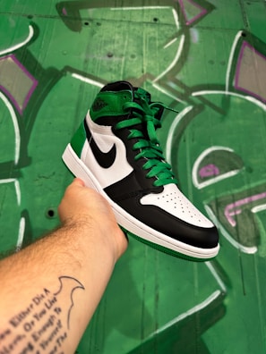 Close-up of vibrant Nike sneakers against a colorful graffiti wall.
