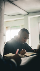 An author deeply immersed in writing, surrounded by notes and sketches.