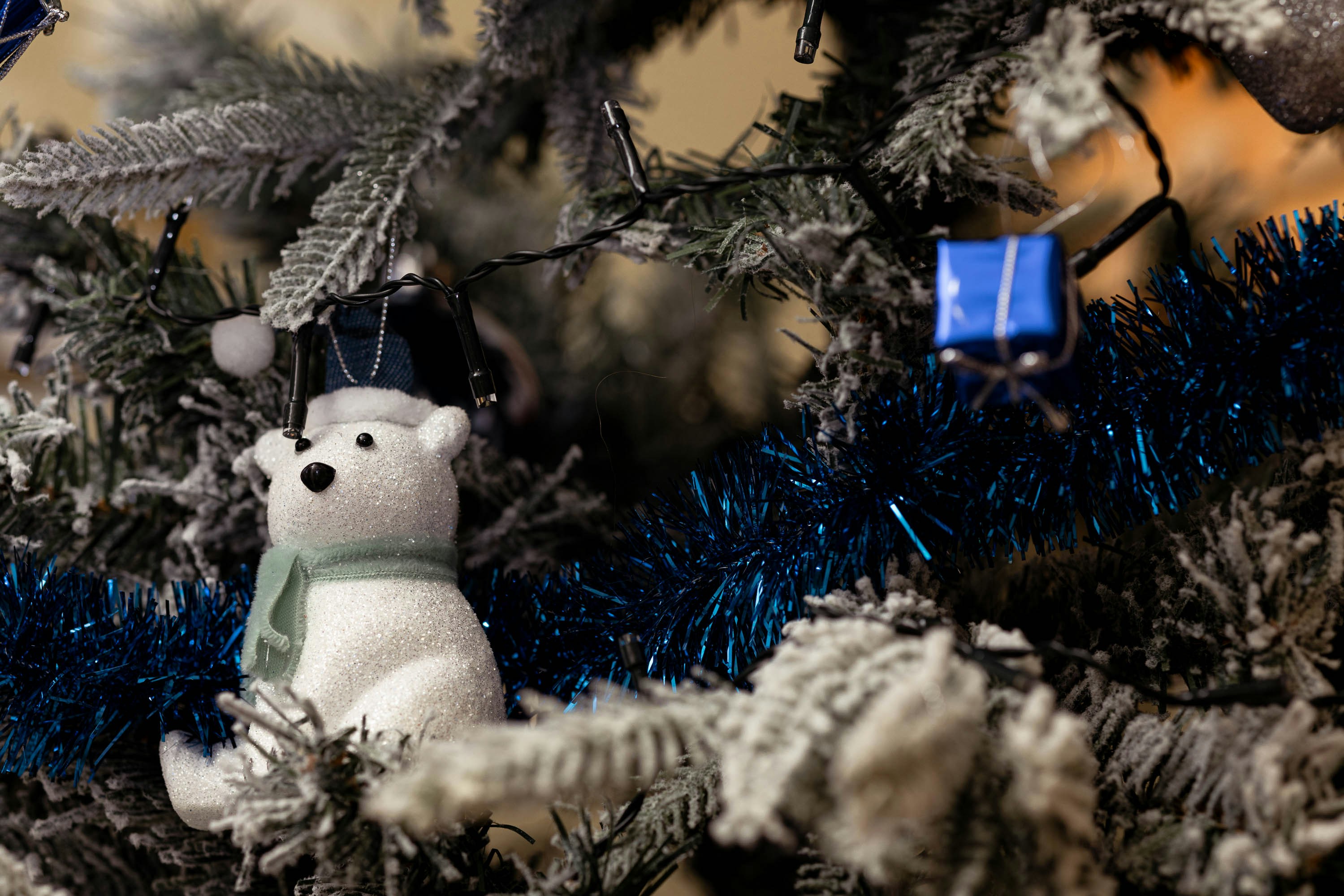 a white teddy bear sitting on top of a christmas tree