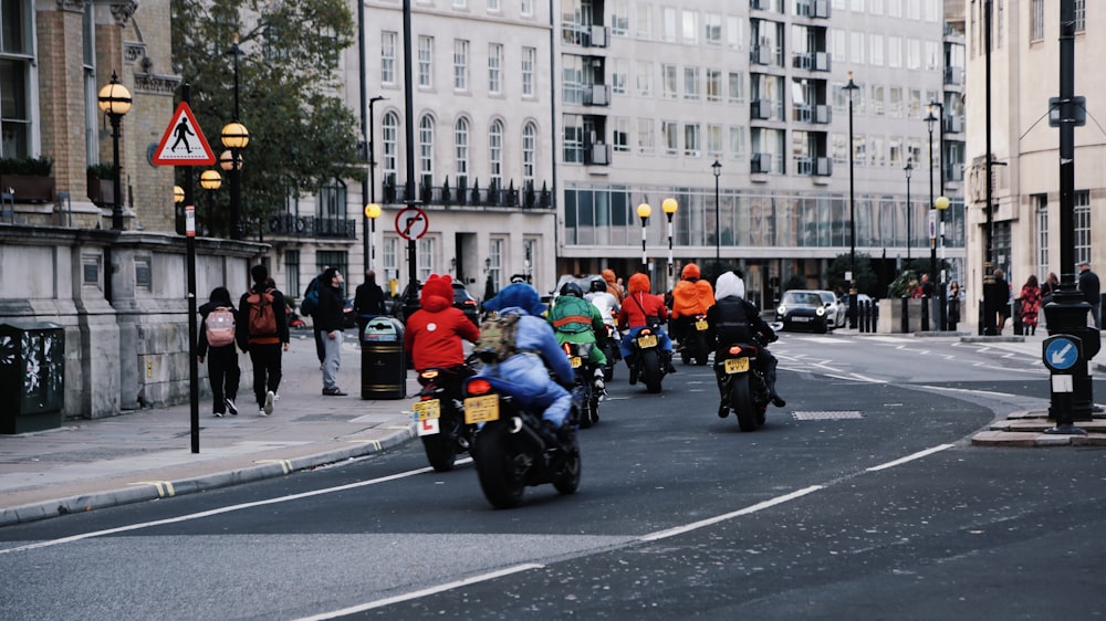 a group of people riding motorcycles down a street