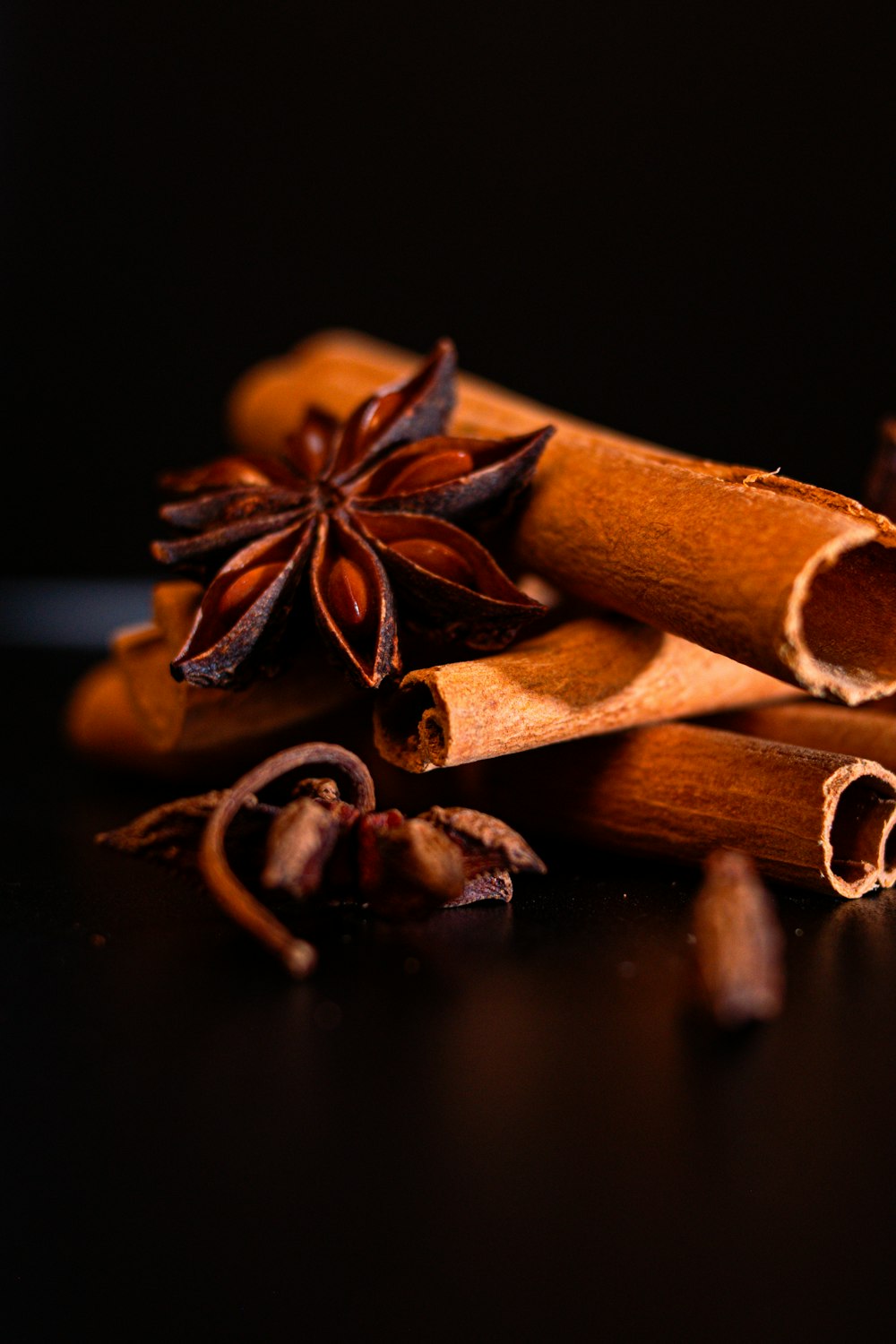 a pile of cinnamon sticks with star anise on top
