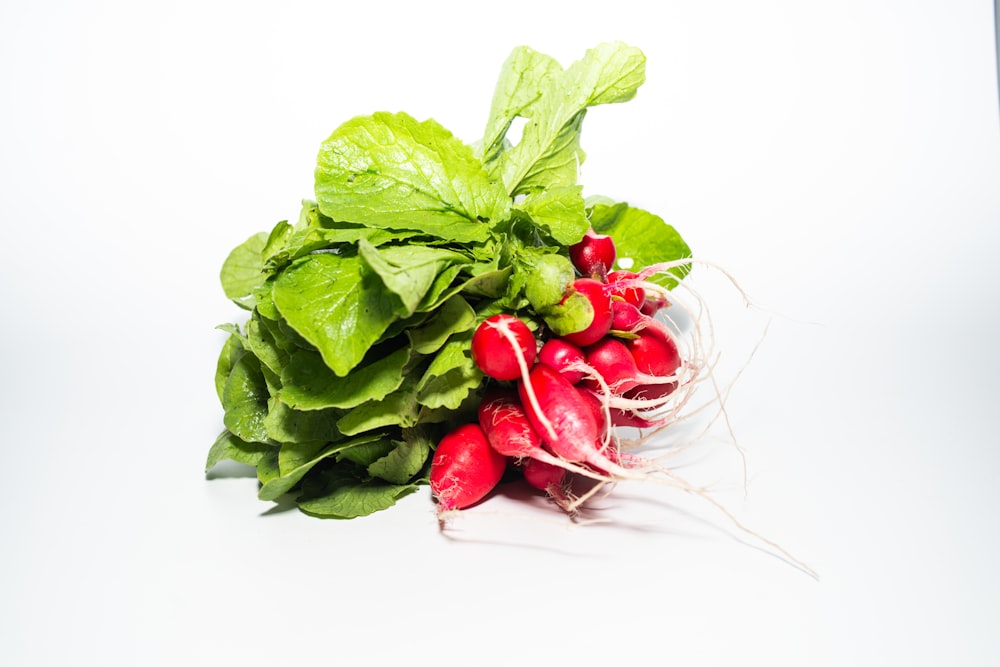 a bunch of radishes with green leaves on a white background
