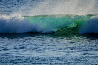 A serene turquoise wave flowing over a calm ocean at sunrise, symbolizing inner peace and vibrant energy.