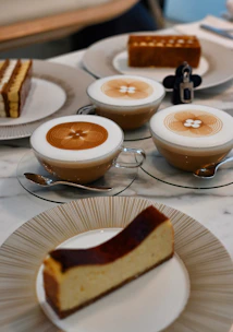 Slices of various cakes served alongside a cup of coffee in a cozy setting.