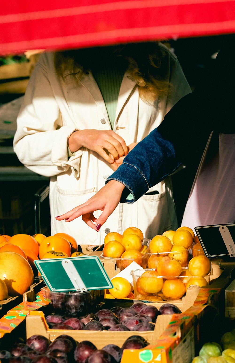 a woman standing in front of a fruit stand