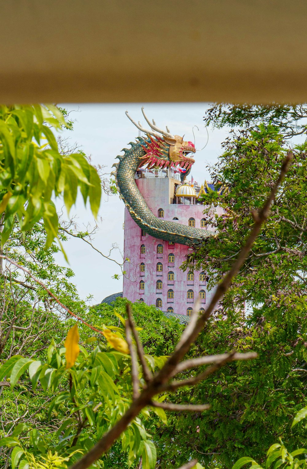 ein rosafarbenes Gebäude mit einem Drachen auf der Spitze