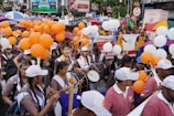 Students marching in formation with drums and flags during a parade