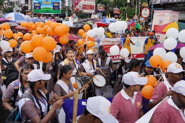 Energetic marchers wearing orange shirts moving through city streets with banners.