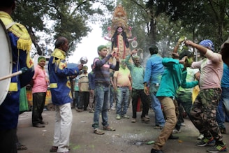 A joyful gathering of community members celebrating a traditional Hindu festival outdoors.