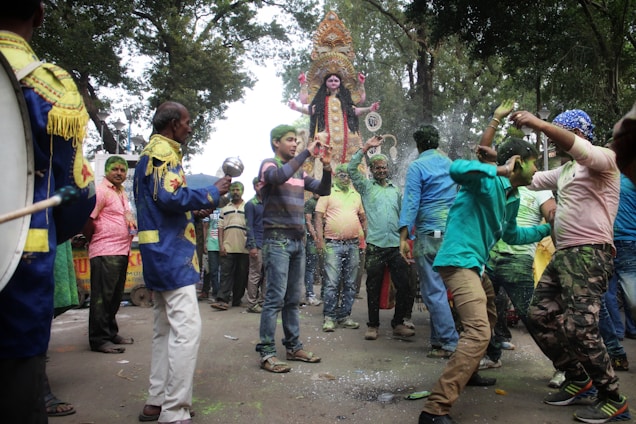 A joyful gathering of community members celebrating a traditional Hindu festival outdoors.