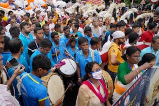 A joyful crowd holding blue pens in tribute to Manoel Gomes.