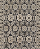 Intricate floral and geometric patterns in symmetrical arrangements dominate the textile design. Cream-colored motifs stand out against a dark background, forming a network of stylized flowers and ornate shapes. The design is bordered by a repetitive pattern of similar motifs.