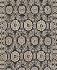 Intricate floral and geometric patterns in symmetrical arrangements dominate the textile design. Cream-colored motifs stand out against a dark background, forming a network of stylized flowers and ornate shapes. The design is bordered by a repetitive pattern of similar motifs.