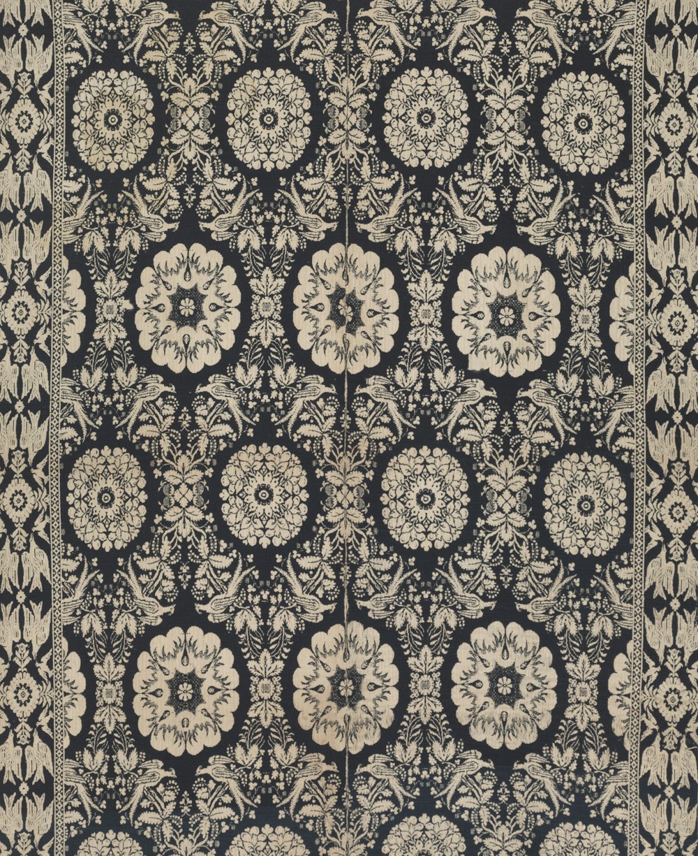 a black and beige rug with a floral design