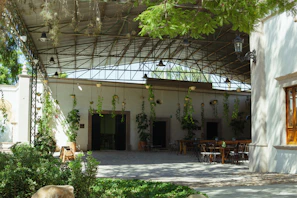 A spacious metal roof structure providing shade over a backyard patio.