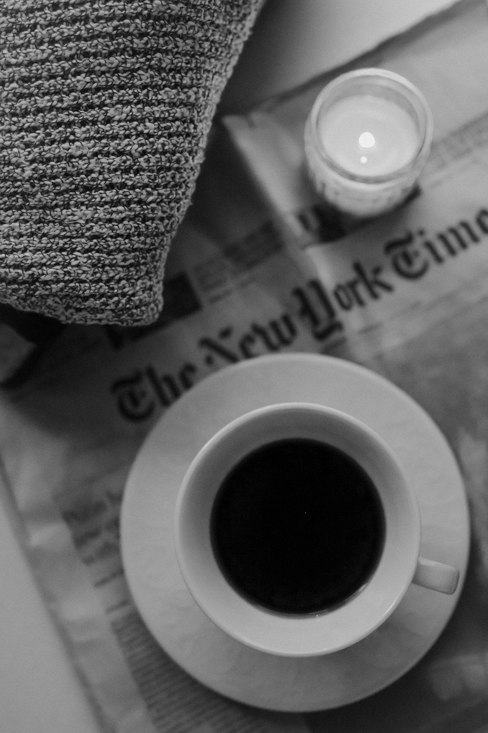 a cup of coffee sitting on top of a newspaper