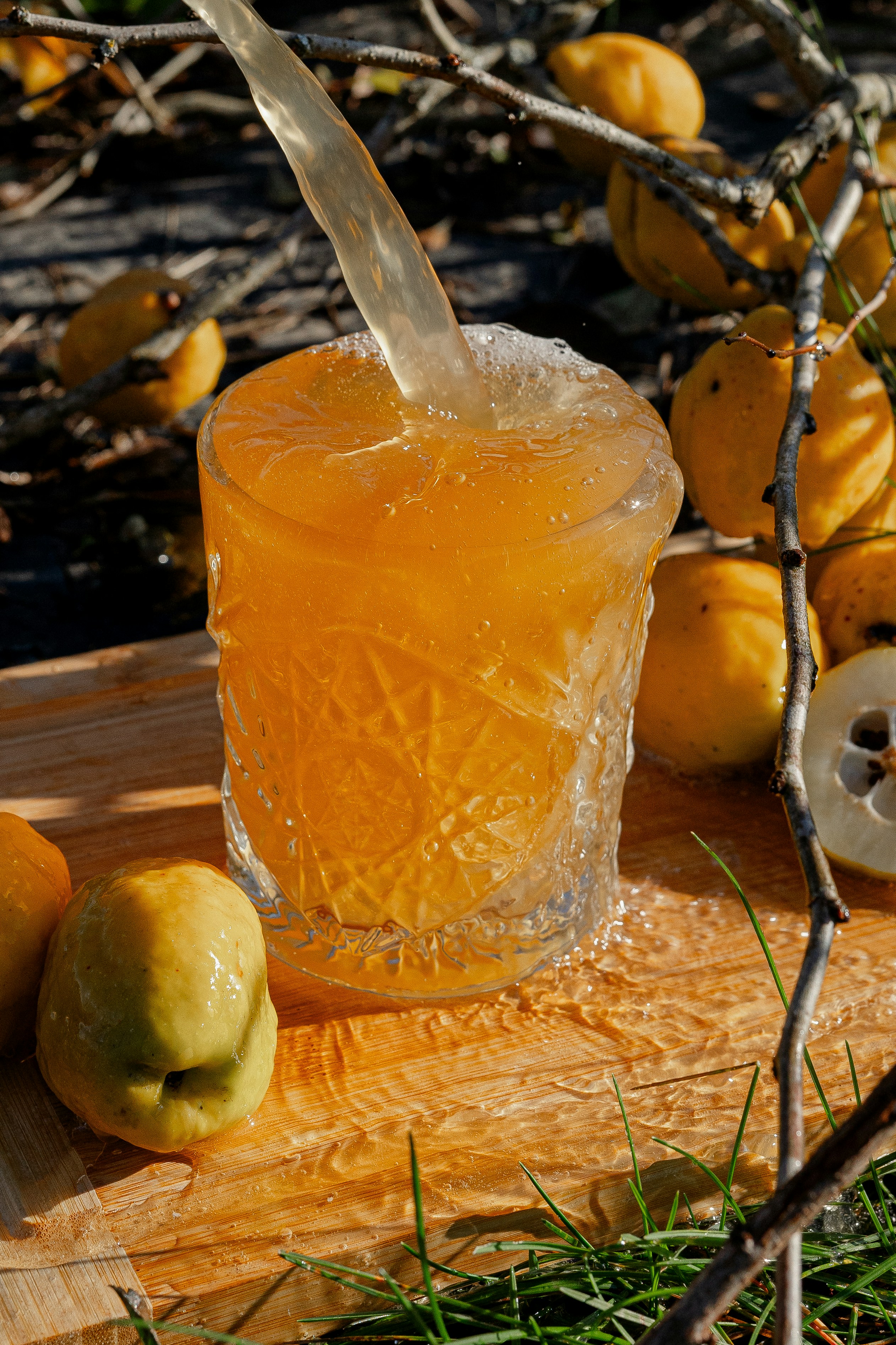 ein hölzernes Schneidebrett mit einem mit Flüssigkeit gefüllten Glas