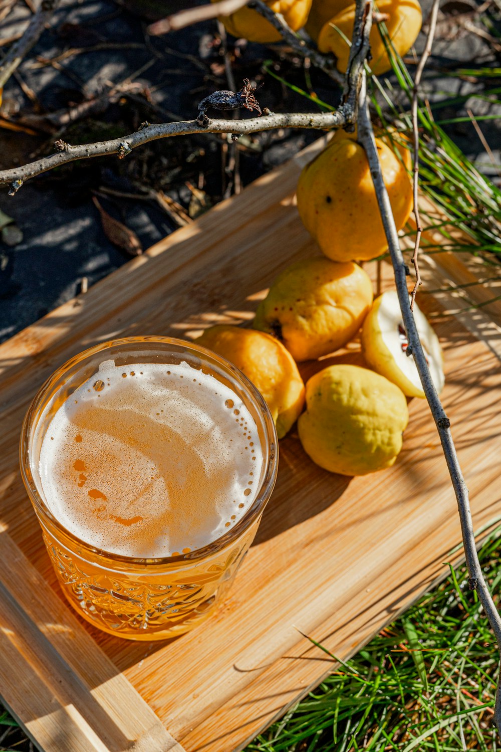 a glass of beer sitting on top of a wooden tray