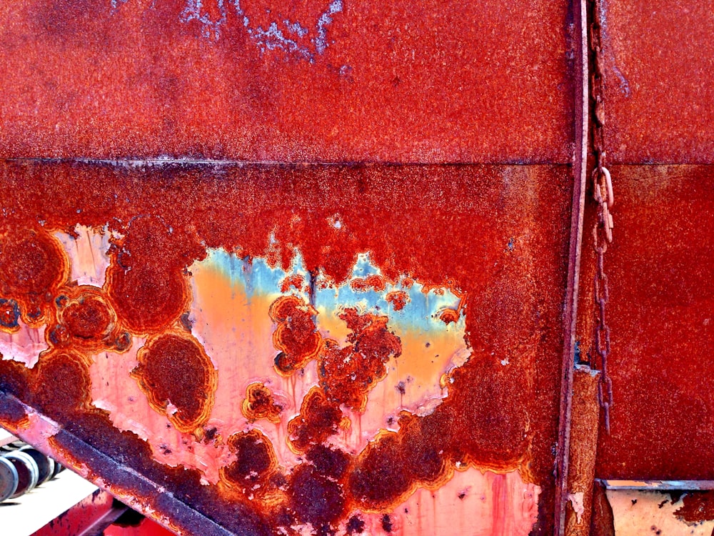a rusted metal surface with a red background