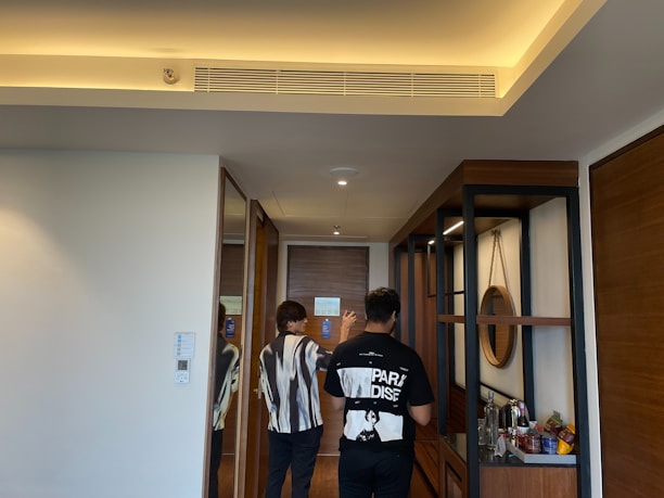 A real estate agent showing property plans to a couple in a modern office setting.
