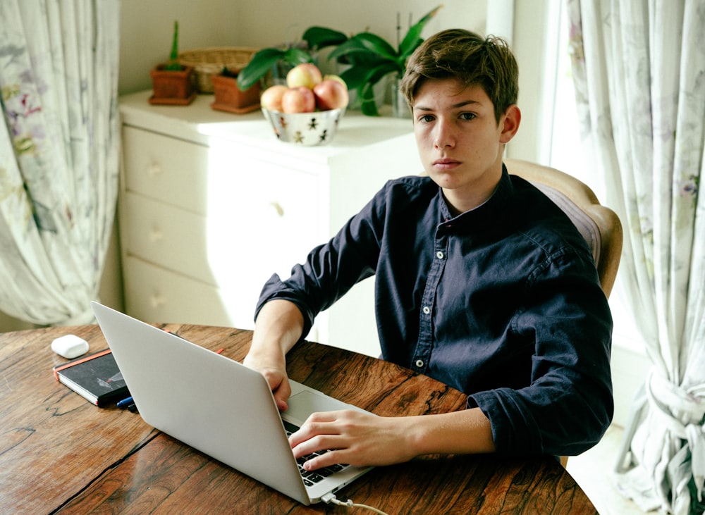 a man sitting at a table using a laptop computer