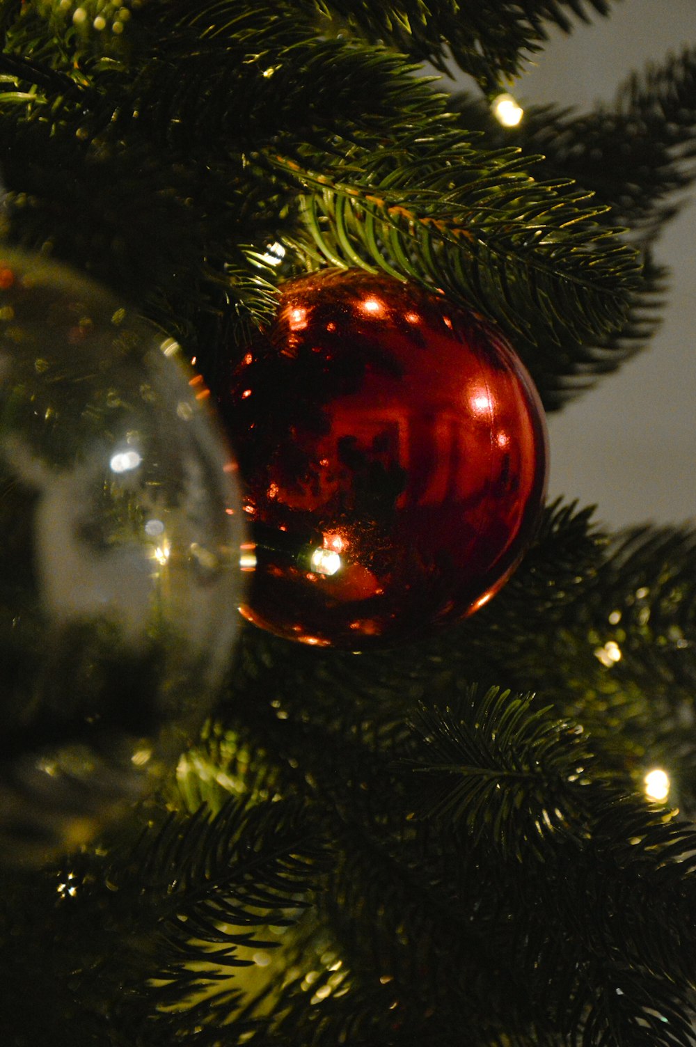 a red ornament hanging from a christmas tree